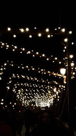 Group of people at illuminated street lights at night