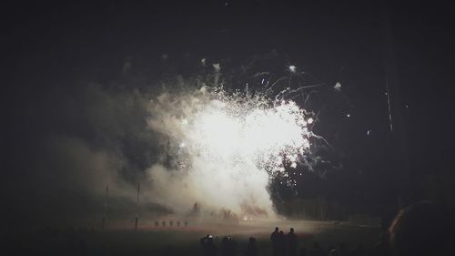 Low angle view of firework display at night