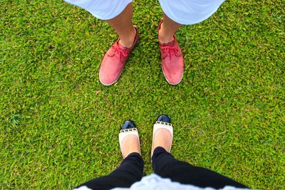 Low section of people standing on grassy field