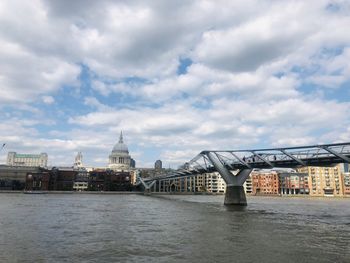 Bridge over river against cloudy sky