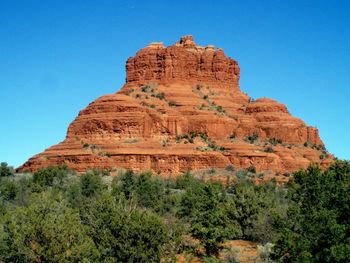 Low angle view of rock formation against clear blue sky