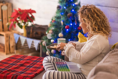Midsection of woman holding umbrella at home
