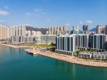 Buildings by swimming pool in city against sky