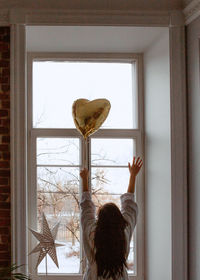 Close-up of woman with air heart at home