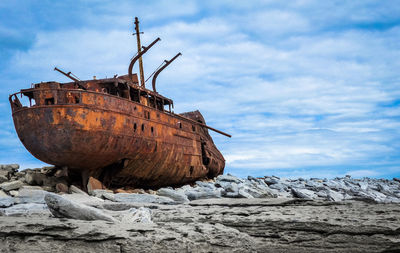Abandoned ship on sea against sky