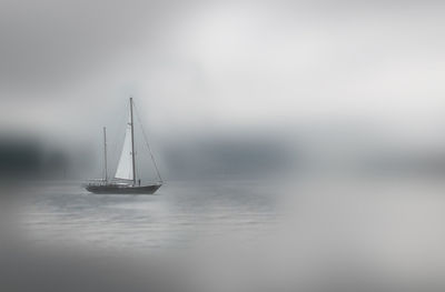 Sailboat sailing on sea against sky