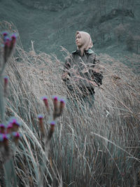 Woman on field with flowers in background