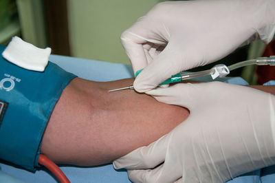 Close-up of doctor giving iv drip to patient at hospital