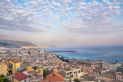 High angle view of town by sea against sky