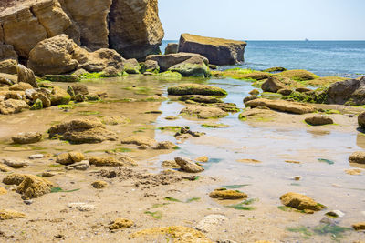 Rocks on beach against sky