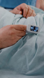 Close-up of man using mobile phone on bed