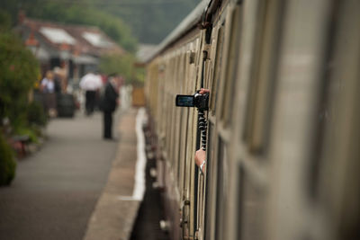 Cropped image of person using home video camera in train