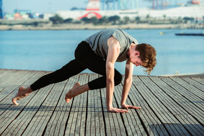 Side view of boy on pier over sea