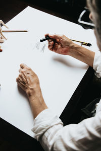 Cropped image of woman painting on paper