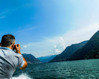 Rear view of man in sea against sky