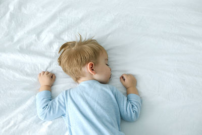 Portrait of cute baby boy sleeping on bed