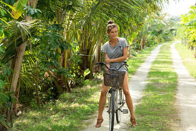 Rear view of woman riding bicycle on field