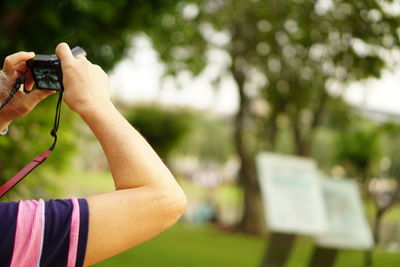 Close-up of woman photographing with camera in park
