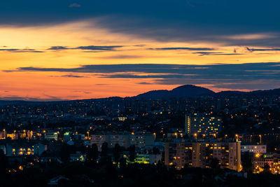 High angle view of illuminated buildings against sky at sunset