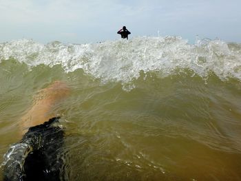 Man surfing in sea against sky