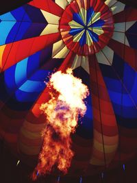 Low angle view of fire in colorful hot air balloon