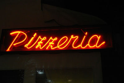 Low angle view of illuminated neon sign at night