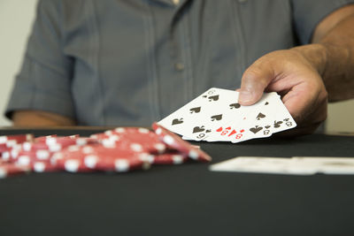 Close-up of man playing poker on table