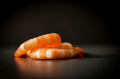 Close-up of bread on table against black background