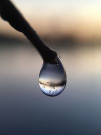 Close-up of water drop on sea against sky