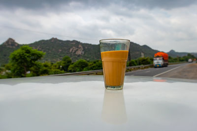 Hot tea filled in glass at highway side from unique perspective at day