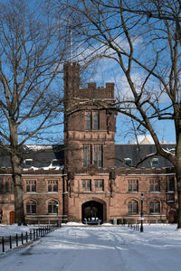 Built structure by snow covered buildings against sky