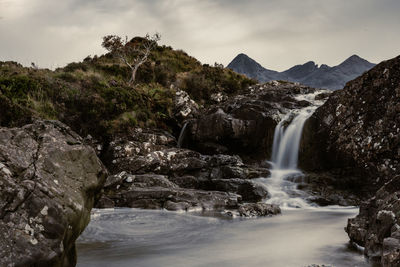 Scenic view of waterfall against sky