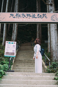 Rear view of woman on road sign