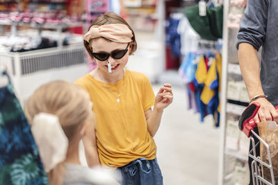 Smiling girl trying sunglasses in shop