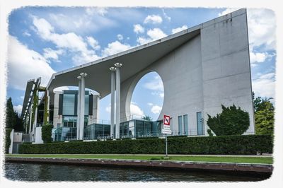 Bridge over river against cloudy sky