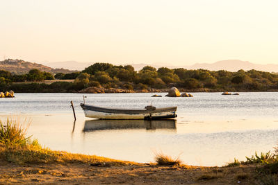 Boat moored on beach against clear sky