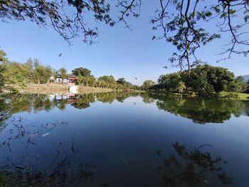 Scenic view of lake by trees against sky