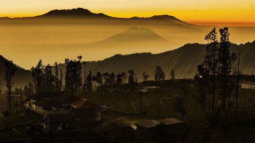 Scenic view of silhouette mountains against sky at sunset