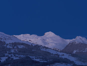 Scenic view of snowcapped mountains against clear blue sky