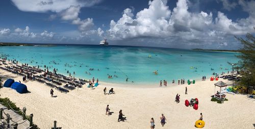 Panoramic view of people on beach against sky