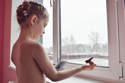 Side view of shirtless man using mobile phone at home