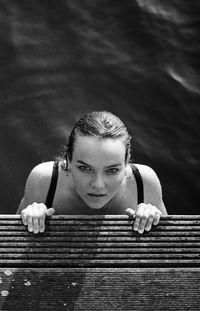 Portrait of smiling young woman by pier outdoors