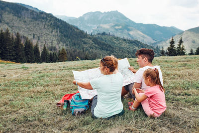 Rear view of women sitting on mountain road