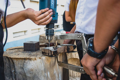 People working on metal with tools