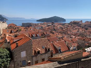 High angle view of townscape by sea against clear sky