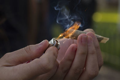 Close-up of hand holding burning outdoors
