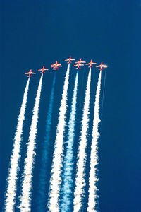 Low angle view of airplane flying against clear blue sky