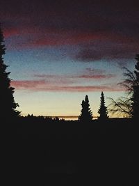 Silhouette trees on landscape against sky at sunset