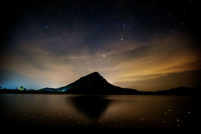 Scenic view of lake against sky at night