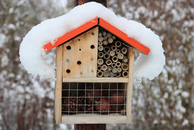 Snow on the roof of an insect hotel / bug house in the garden.